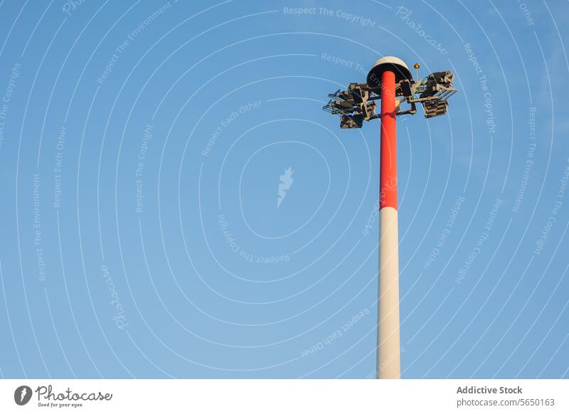 Airport Tarmac Floodlight Pole Against Sky airport tarmac floodlight pole sky blue lighting outdoor safety security navigation flight equipment facility tall