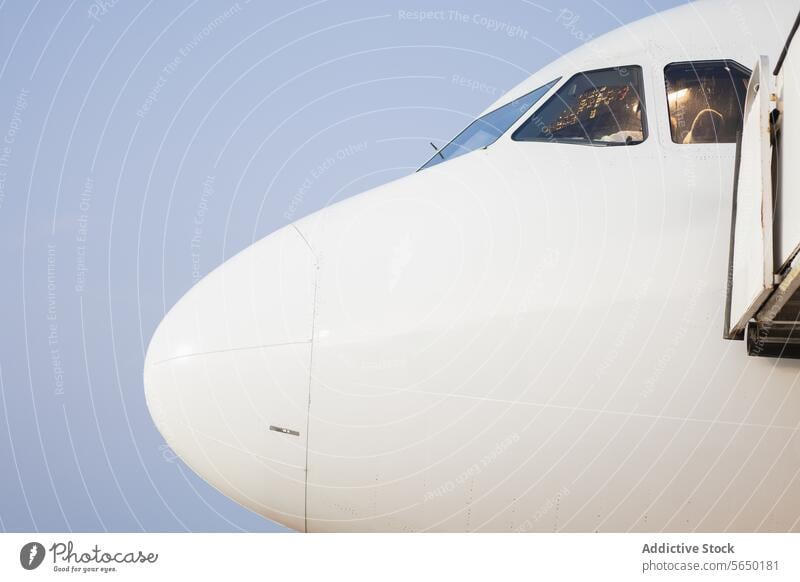 Close-Up of Airplane Cockpit Windows" airplane cockpit window close-up reflection sky pilot aviation aircraft nose front jet travel transport flight commercial