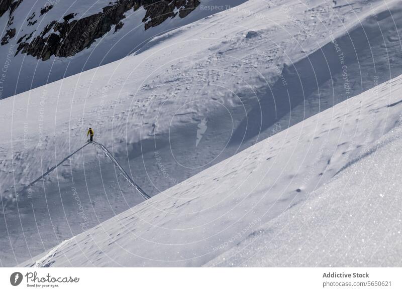 From above of Anonymous Tourist in ski suit skiing on mountain slope during vacation at Swiss Alps Skier Slope Snow Mountain Adventure Courage Motion Sport