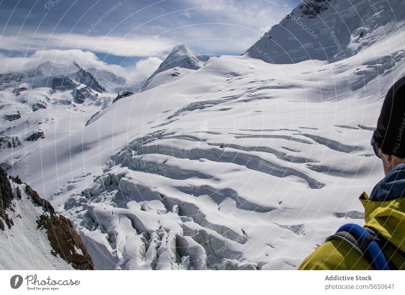 Crop Unrecognizable male tourist in warm clothes and sunglasses admiring snowy landscape under cloudy sky in Zermatt Man Hiker Snow Mountain Nature Rocky