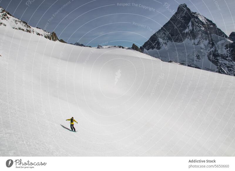 Back view of anonymous Snowboarder in action enjoying vacation on snowy mountain in Zermatt under blue sky Tourist Sport Mountain Slope Vacation Action