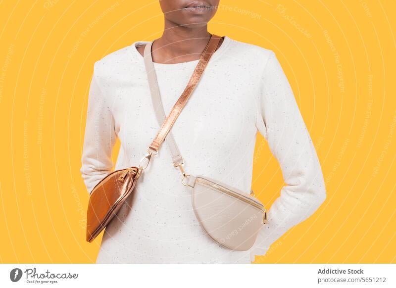 Anonymous fashionable black woman in sling bag isolated on yellow background trendy accessory purse african american elegance strap lifestyle white material