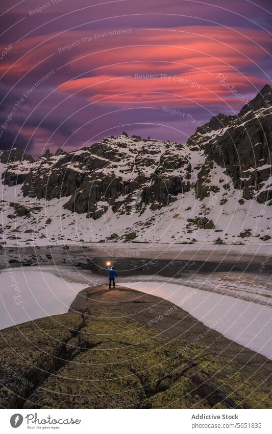 Twilight explorer in Icelandic wilderness iceland twilight adventure traveler sky pink purple dusk landscape nature scenic snow rugged terrain outcrop moss