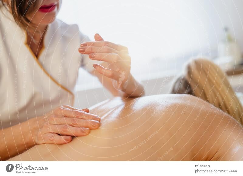 Close-up of a massage therapist's hands over a client's back, ready to massage. beauty salon Wellness Hotel Concept image hotel massage oils physiotherapist