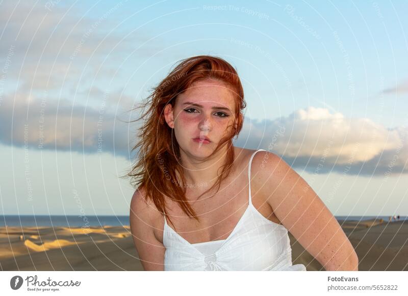 Young woman on the beach with windblown hair white copy space active teenager desert cute dress European beauty young windy vacation lifestyle day girl female