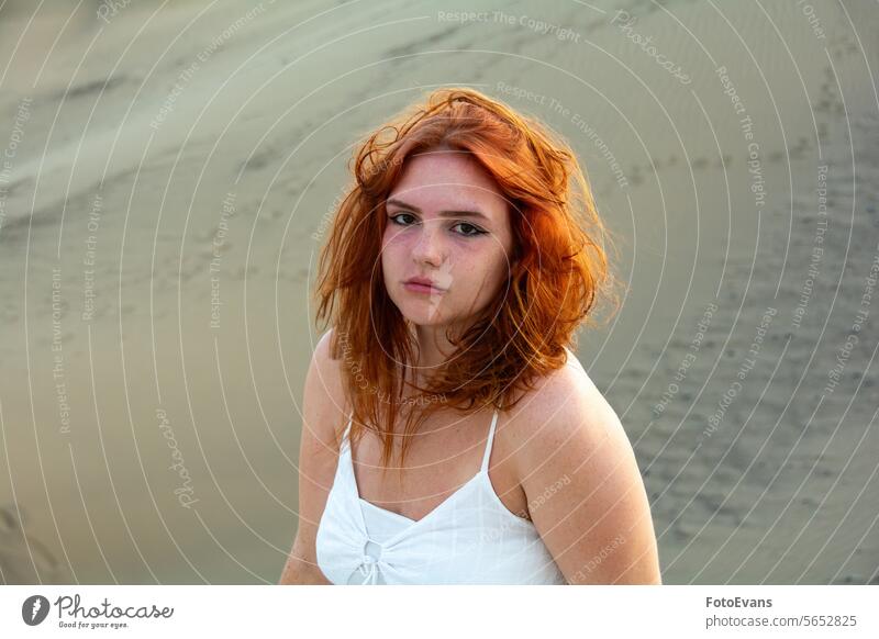 Young woman on the beach with windblown hair and slight sunburn on the face white copy space active teenager desert cute dress European beauty young windy