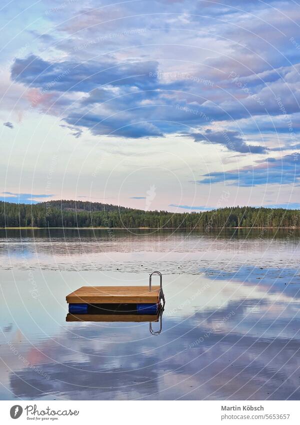 Swimming island in Sweden on a lake at sunset. Clouds reflected in the water. swimming island wooden island silence swimming fun paradise summer reflection