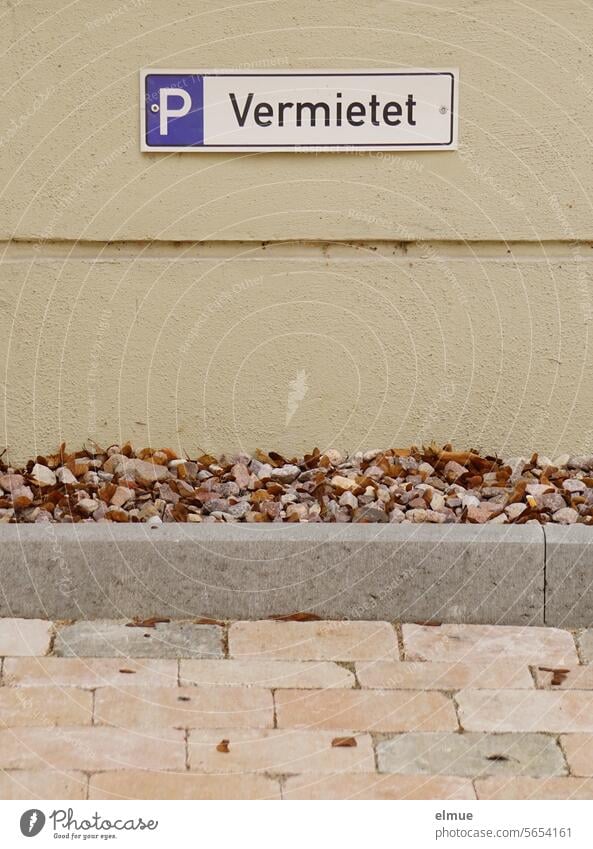 Sign - P Rented - on a wall behind a paved parking lot with a stone boundary Parking lot sign parking sign rented rented parking lot Parking space