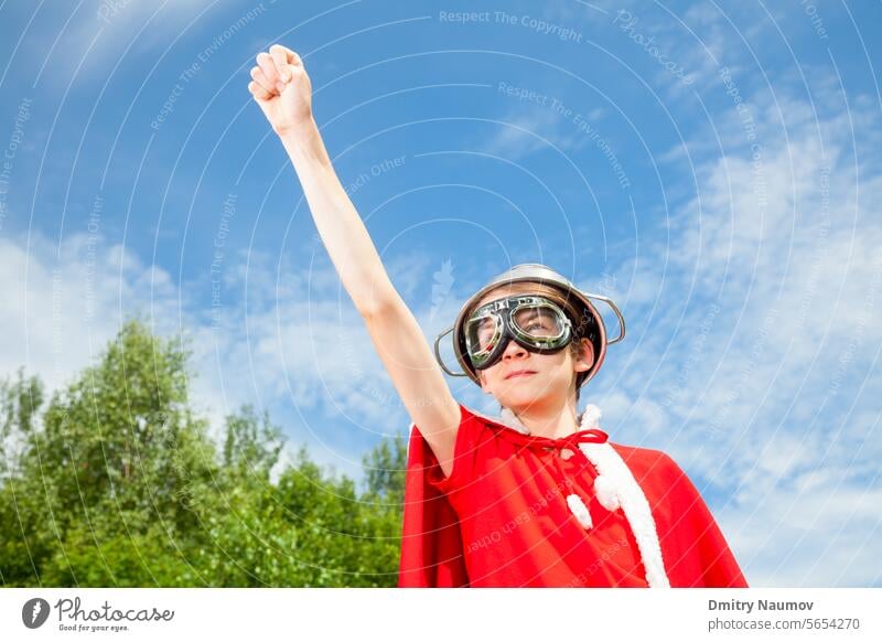 Kid playing Superhero aspirations boy cape child childhood colander concept confident costume cute dream fight fun funny game goggles helmet imagination kid