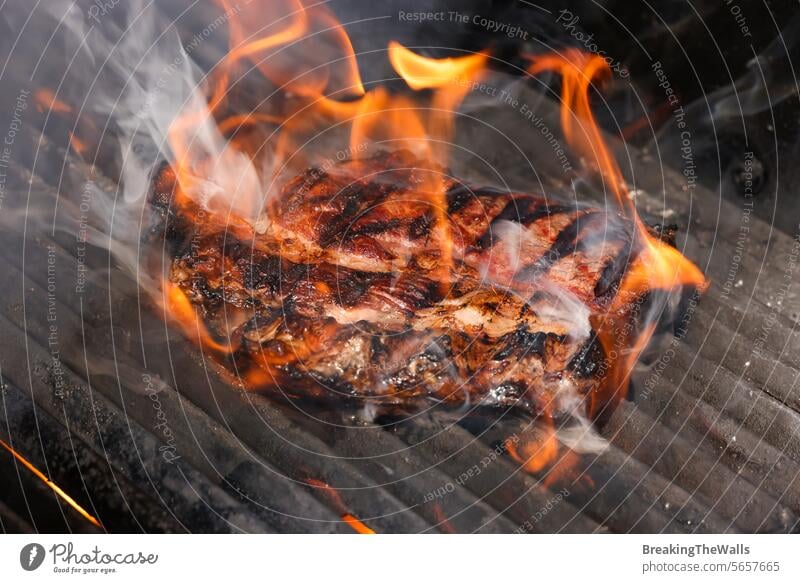 Searing and smoking ribeye steaks on grill Ribeye rib eye beef raw marbled meat bbq barbecue fire flame smoke sear sizzle broil cook closeup grate metal