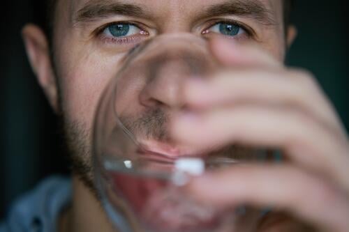 Man drinks clean water from glass man thirst fresh mineral healthcare metabolism beverage healthy pure clear adult water balance drinking water person mouth