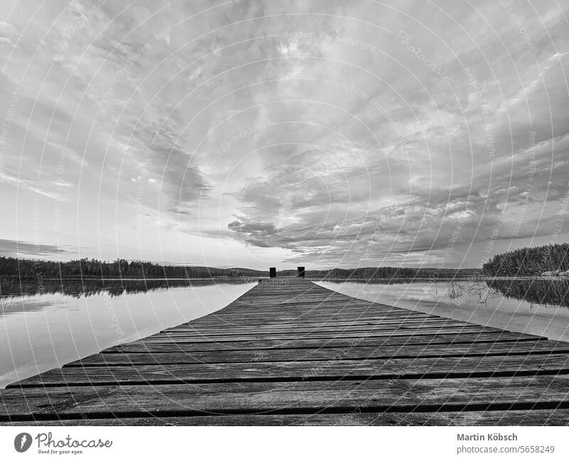 Wooden jetty jutting into a Swedish lake in black and white. Nature photograph bathing evening beautiful dusk fog travel calm landscape horizon evening mood