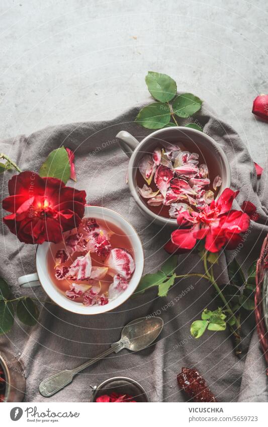 Herbal tea with red roses petals, top view herbal tea cup mug natural pink table healthy drink beverage flower above overhead flat lay