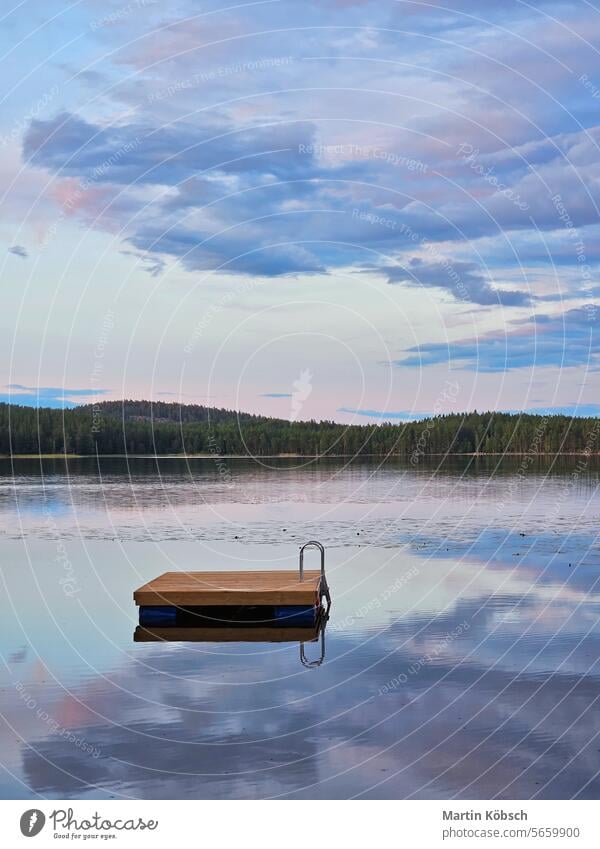 Swimming island in Sweden on a lake at sunset. Clouds reflected in the water. swimming island wooden island silence swimming fun paradise summer reflection