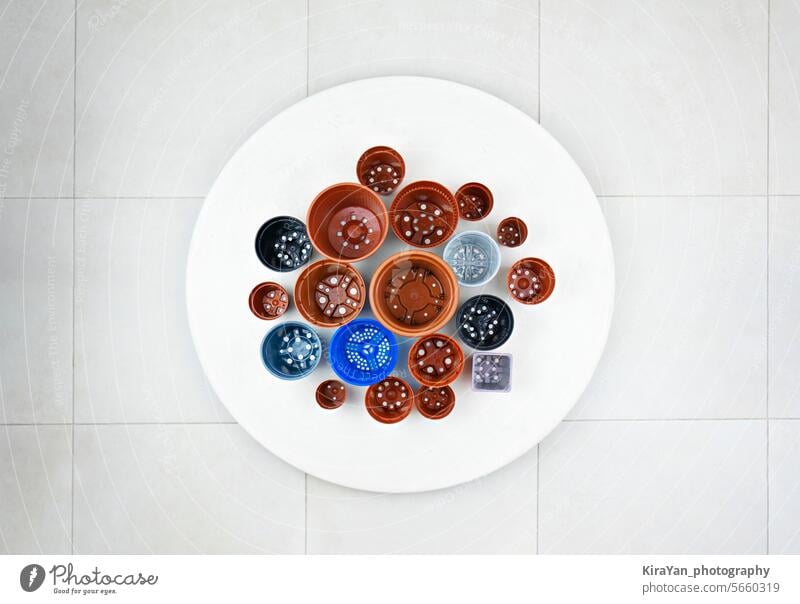 Variety of plastic pots displayed on white table, view above variety ceramic pottery clay terracotta glazed artisan craft collection decorative design