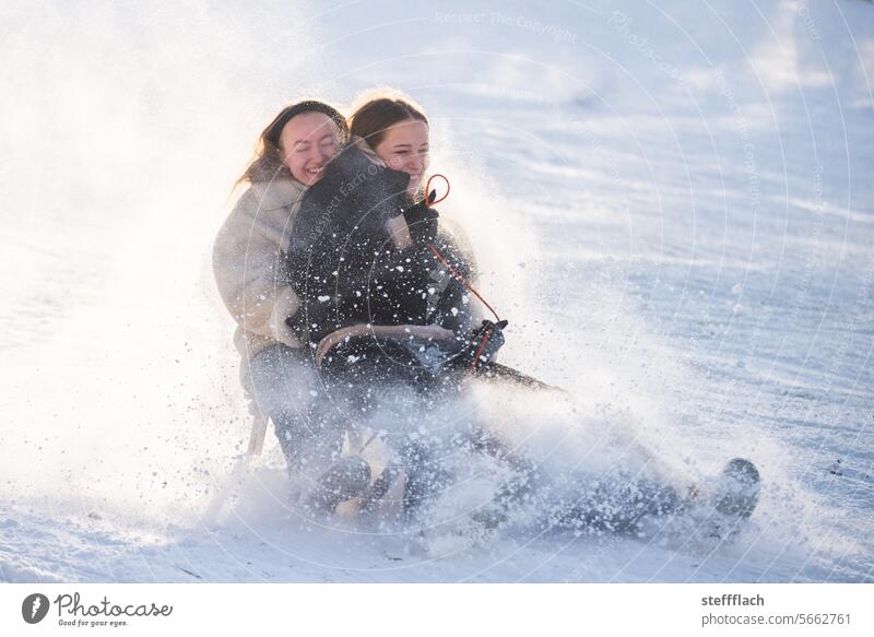 Two teenagers race through the sunshine on a sled, dusted with snow Snow Winter Sleigh sledging children Child Sunlight Sledding Sledge Toboggan run Cold