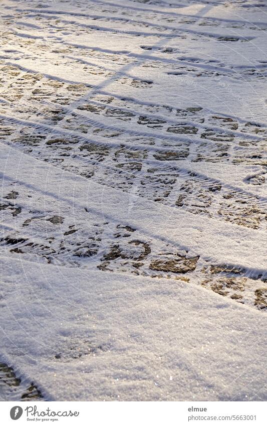 Tire tracks on a slightly snow-covered paved road Skid marks Winter paving Wintry road conditions Snow snowy Cold Street Winter mood winter Winter's day Weather