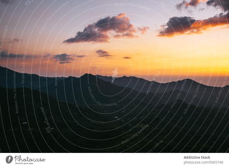 Mountain sunset with orange-hued skies in Minca, Colombia mountain sky cloud tranquil peak layered warm dusk scenery nature outdoor landscape serene twilight