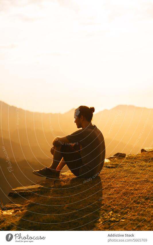 Contemplative person enjoying a serene sunset in Minca, Colombia nature reflection contemplative cliff edge sitting golden light tranquil beauty outdoor