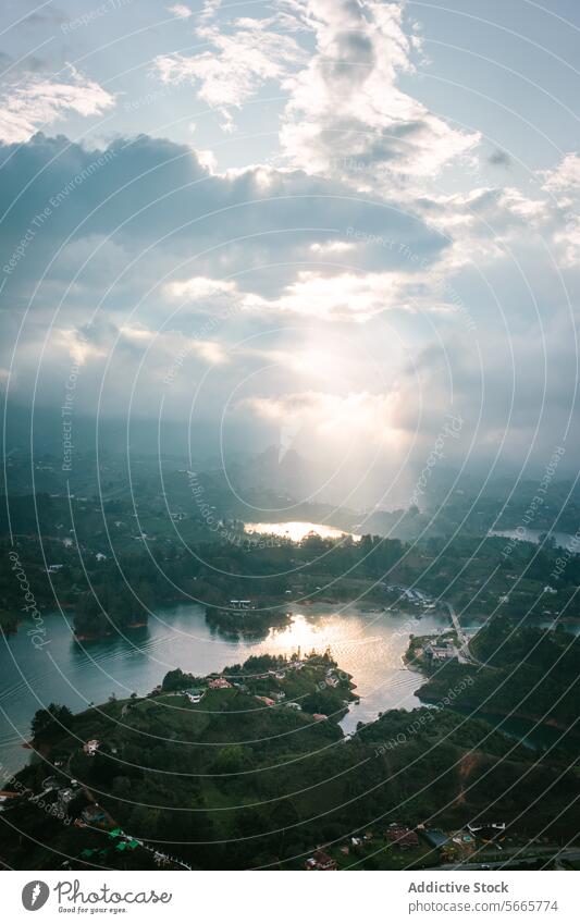 Serene lake view at dusk with soft sunlight in Guatapé landscape tranquil clouds greenery elevated glow serenity water nature scenic peaceful outdoors beauty