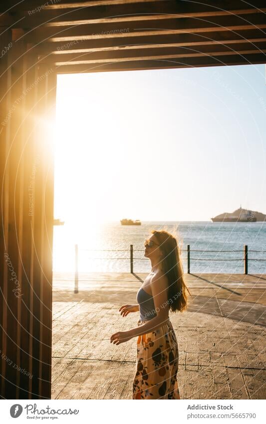 Serene sunset by the sea with thoughtful woman tranquil contemplative golden sunbeam silhouette shadow frame peaceful serene seacoast reflective evening light