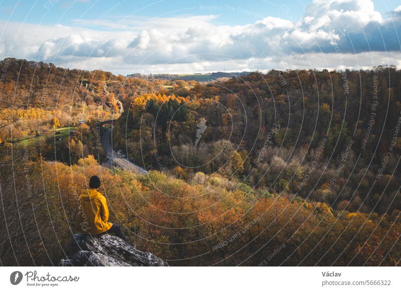 Rocky environment near the town of Dinant in Wallonia region, Belgium with a watercourse that forms natural meanders in autumn colour. The sunset illuminates a colourful forest