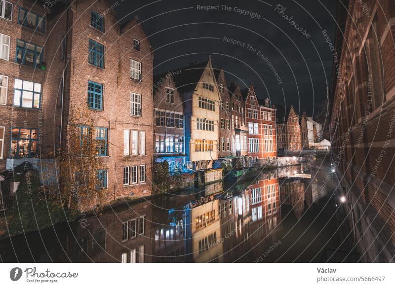 View of classic medieval houses reflected in a water canal in the centre of Ghent, Flanders region, Belgium. Colourful facades of the houses of rich citizens