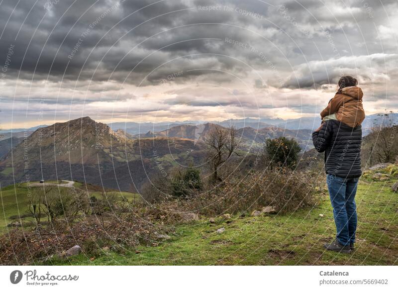 The man and the toddler on his shoulders look out over the landscape stones Clouds bushes vacation Tourism Vacation & Travel Mountain Landscape mountain