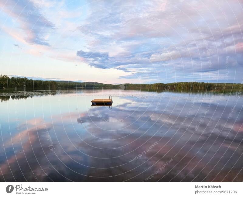 Swimming island in Sweden on a lake at sunset. Clouds reflected in the water. swimming island wooden island silence swimming fun paradise summer reflection