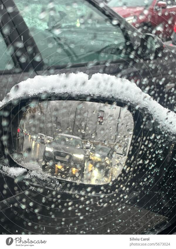 Closeup of car mirror with snow among the splashes on the glass storm frost season winter icy freeze cold temperature blizzard climate blue white weather glacé