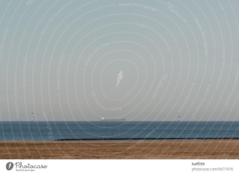 Calm panoramic shot of the sea with container ship and navigation signs on the horizon Container ship North Sea coast maritime trade Navigation signs Horizontal