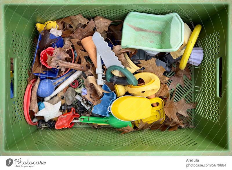 View into a green plastic box with sandpit toys and autumn leaves Sandpit sandbox Toys Playing Infancy Child Children's game Kindergarten Playground Autumn