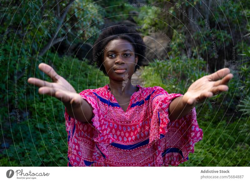 Happy black young woman inviting with open hands invite palm forest tree positive environment nature female african american ethnic welcome park stand friendly