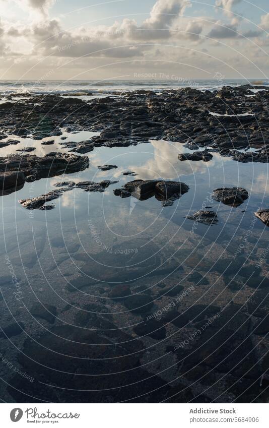 Sunset reflections at Praia Emilia's rocky beach sunset tidal pool rocky shore praia emilia clouds mirror water seaside nature tranquil evening scenery