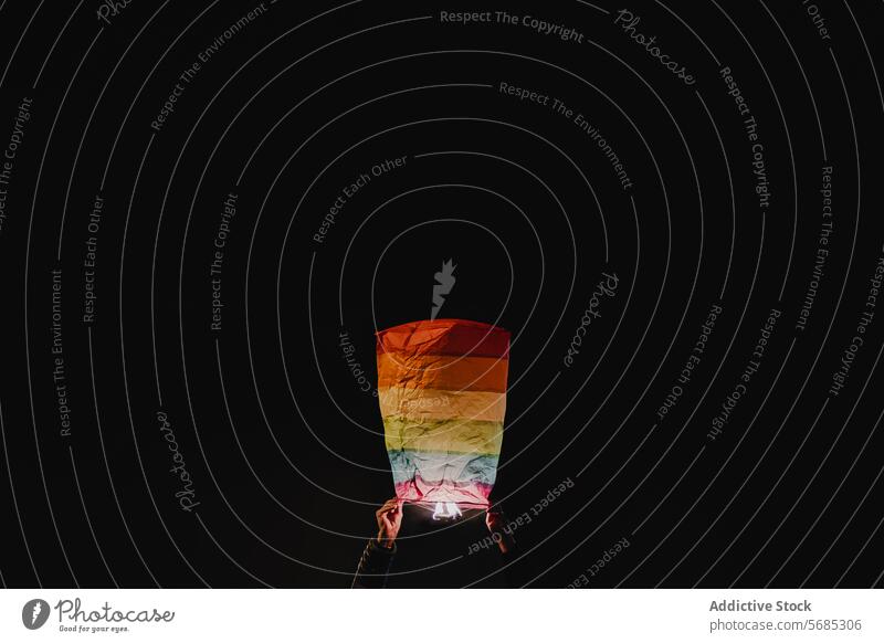 Hand holding a colorful paper lantern in darkness hand background vibrancy celebration hope light illumination night event traditional culture festival glow