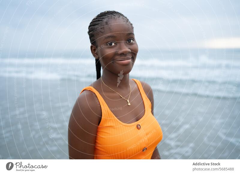 Positive black woman standing on seashore wear necklace style outfit lady positive smile beach ocean vacation female young cheerful accessory happy feminine