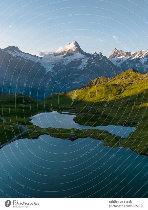 Serene Alpine Lake in Mountainous Landscape at Sunset alpine lake mountain sunset green hill tranquil serene landscape nature beauty calm water rugged backdrop