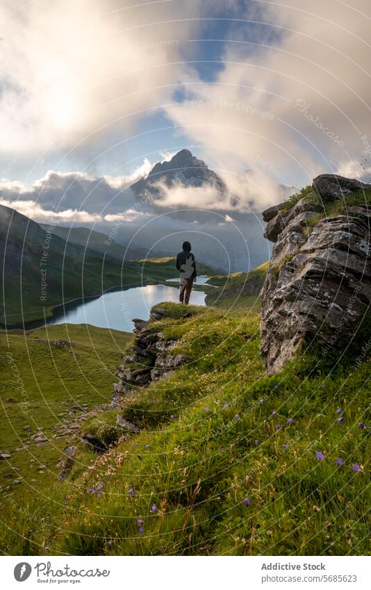 Anonymous man admiring mountain lake at sunrise traveler alpine lake serene majestic peak cloud overlooking solitary nature landscape switzerland grindelwald