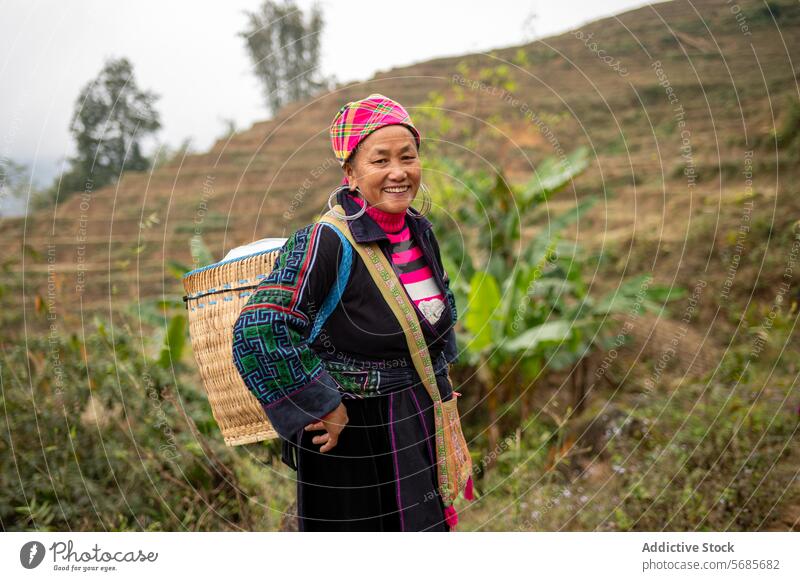 Happy middle aged ethnic woman standing in countryside smile rural hill tree happy cheerful nature female mature asian vietnam bag headscarf vietnamese green