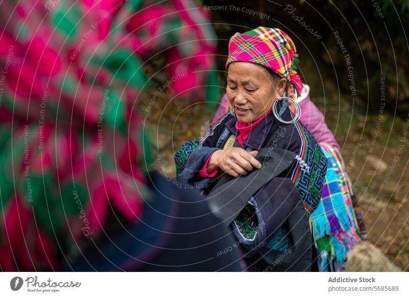 Smiling aged female with clothes in hands standing outside woman smile village path tradition culture countryside headscarf senior settlement elderly local