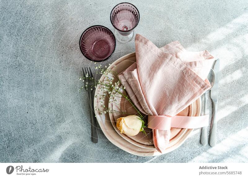 Elegant Easter table setting with pastel accents easter plates napkins flower silverware glassware textured surface delicate tasteful arrangement seasonal