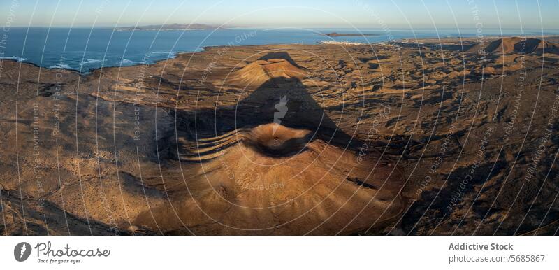 Aerial view of a volcanic landscape and coastline at sunset aerial warm light rugged terrain sweeping ocean lava field crater geology nature natural scenic