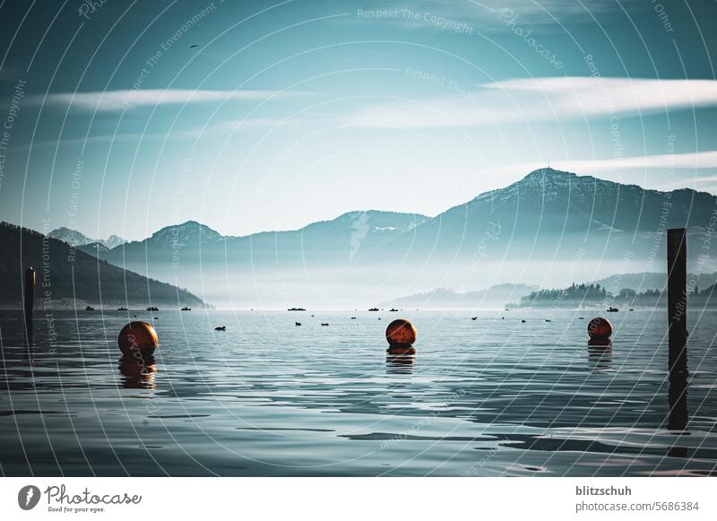 A winter's day at the lake with fishing boats and mountains in the background Lake Buoy buoys Water Nature Landscape Lakeside Vacation & Travel Relaxation