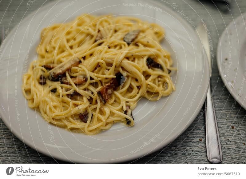 A plate of real Italian carbonara in a restaurant in Milan Plate Edge of a plate carbon macaw Noodles pasta carbonara Authentic authentic cuisine Italian Food