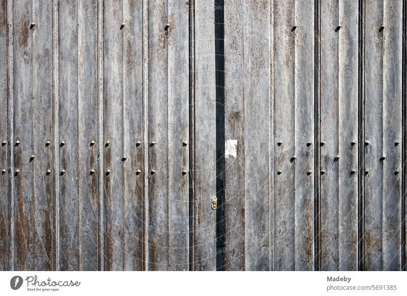 Old gray steel gate with structure, rust, patina in the sunshine in the alleys of the old town of Bruges in West Flanders in Belgium Light Patina Iron Steel