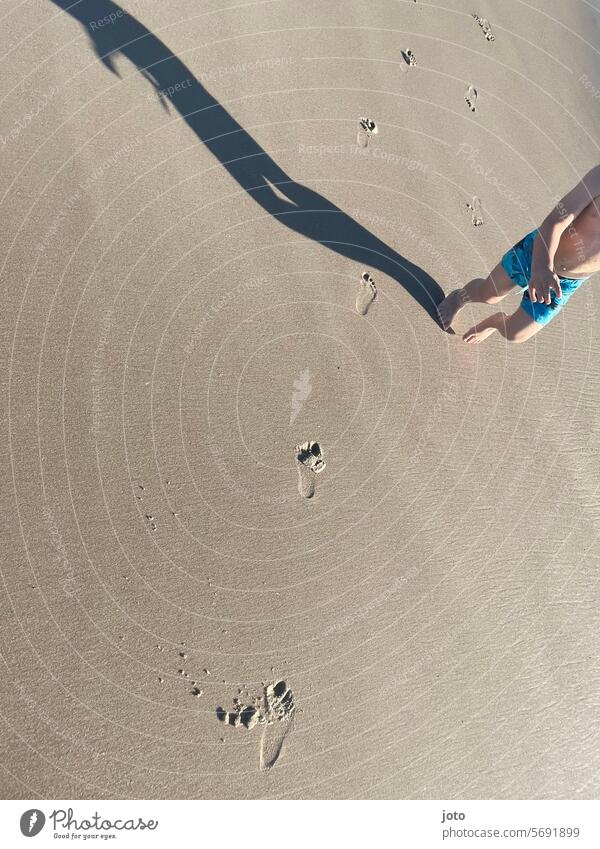 Children leave footprints on the beach and form a shadow Pedestrian Footprints in the sand Sand Sandy beach Beach North Sea coast Shadow shadow cast