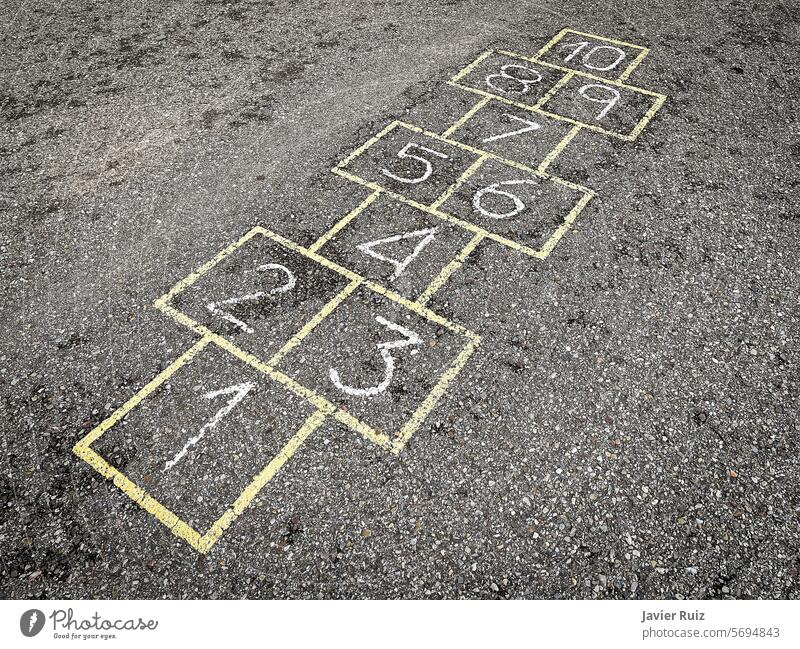 popular hopscotch game painted on the asphalt, childhood games, street games numbers yellow playground fun drawing jump school activity outdoor pavement chalk