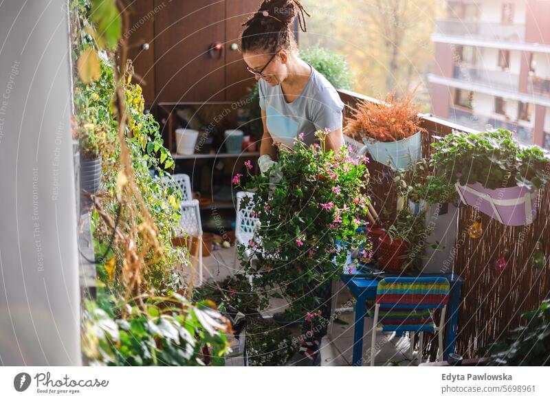 Woman taking care of her plants on the balcony blooming fresh floral blossom hobby florist pot natural person adult botany spring greenhouse lifestyle summer