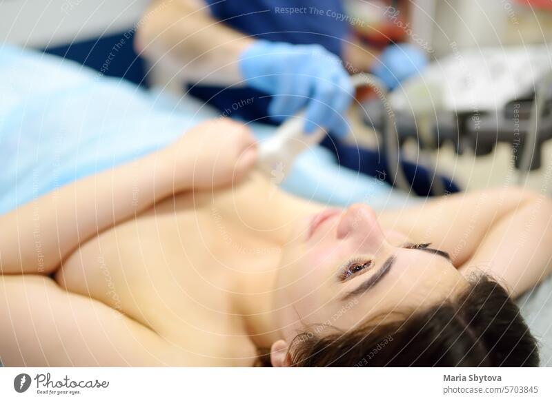 Mammologist doctor examines a woman breasts and lymph nodes using ultrasound. Mammography and ultrasound scanning are main methods of instrumental diagnosis of mammary glands. Breast cancer