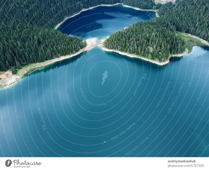 Amazing aerial drone view of Crno Jezero or Black lake, pine forest and cliffs in Durmitor national park, Zabljak, Montenegro. Travel, environment, beauty in nature, relaxing. UNESCO World Heritage